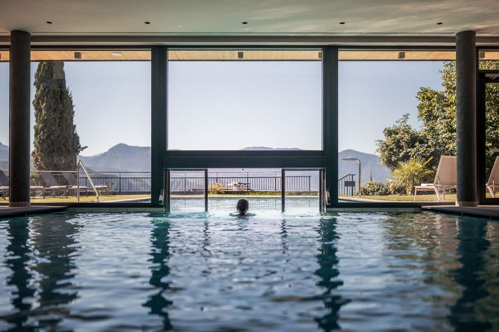 Person im Innenpool mit Bergblick bei klarem Himmel