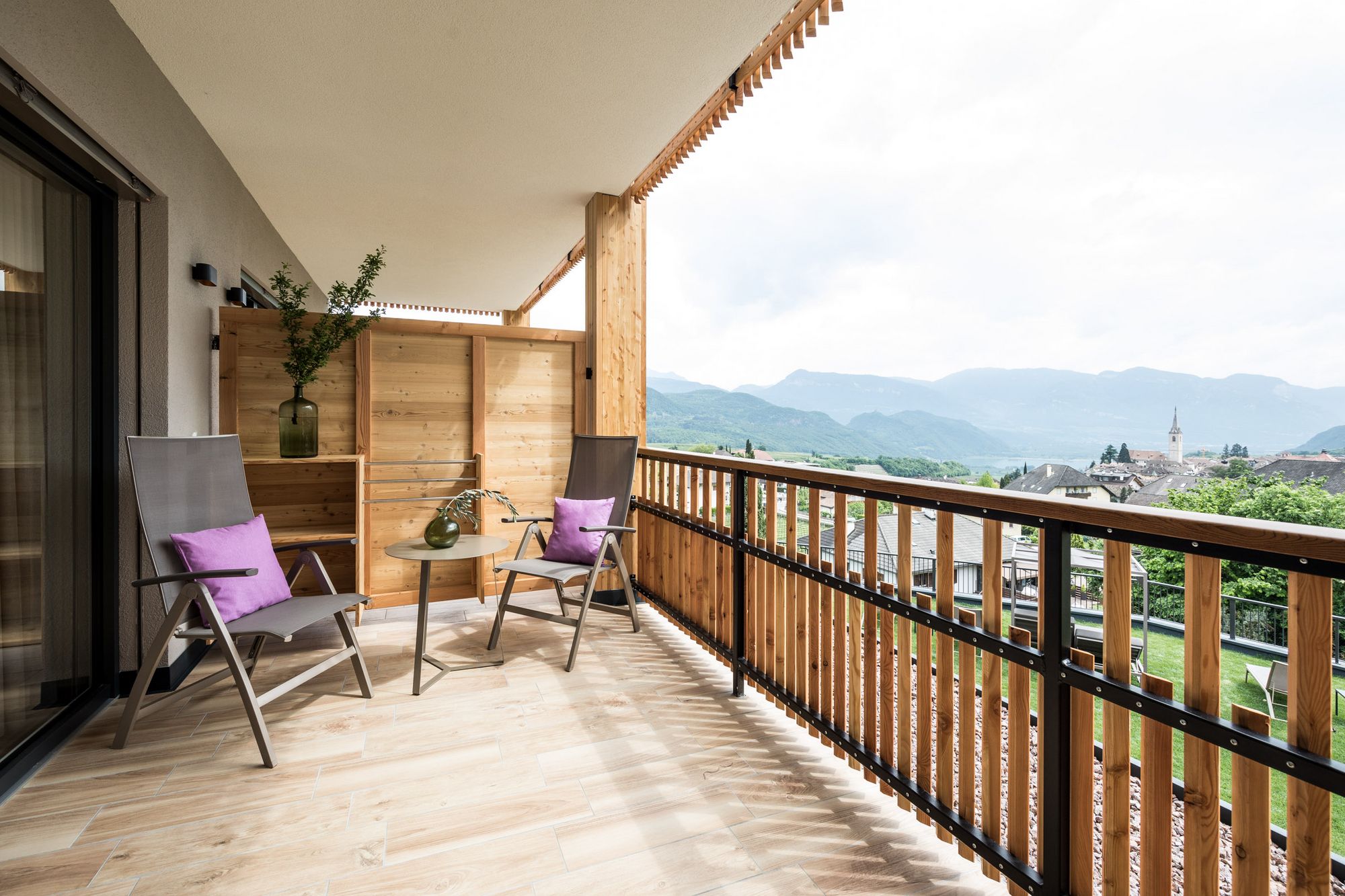 Balkon mit zwei Stühlen, kleinem Tisch und Bergblick