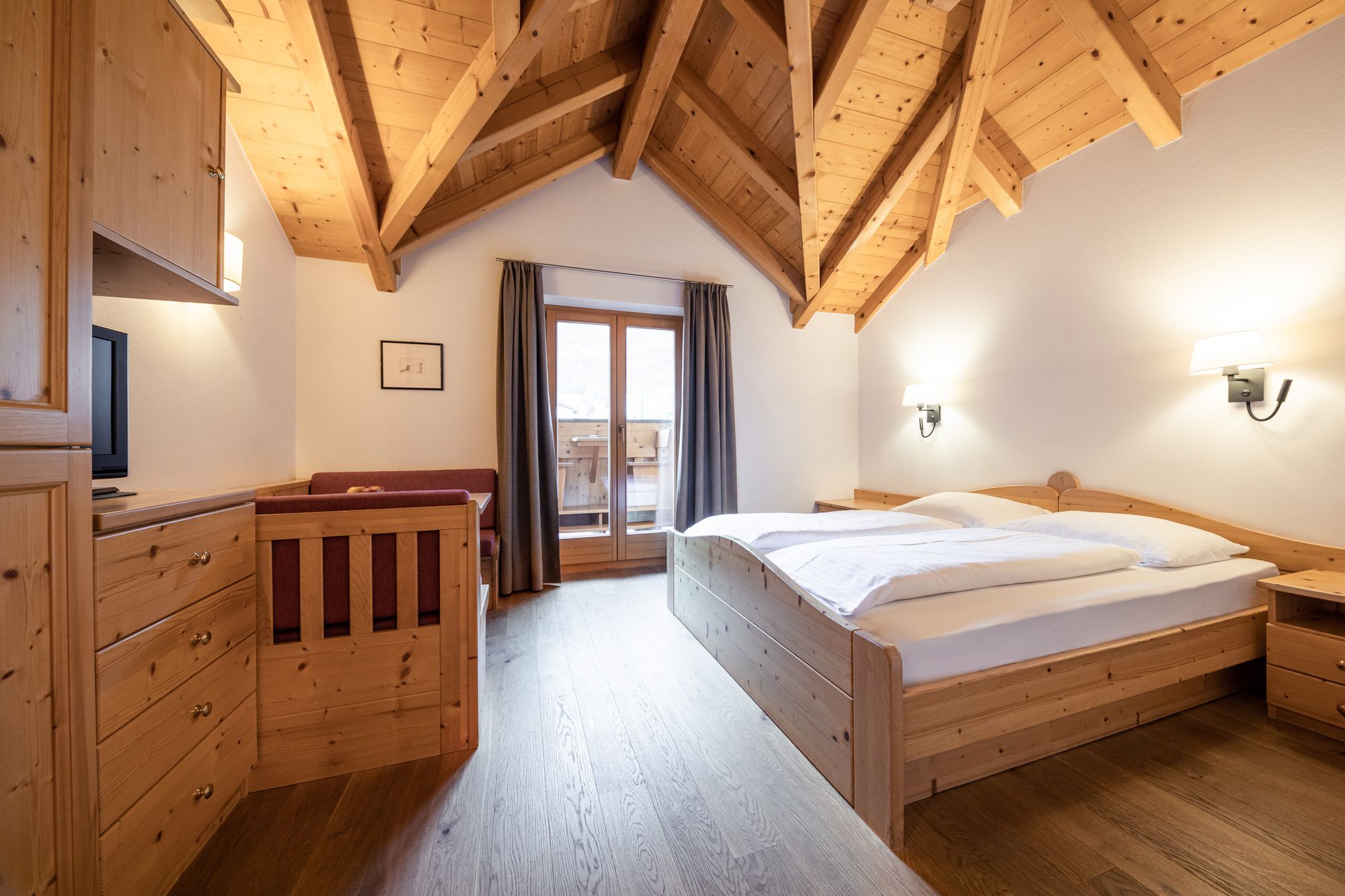 Gemütliches Schlafzimmer mit Holzmöbeln, Doppelbett und Dachschräge