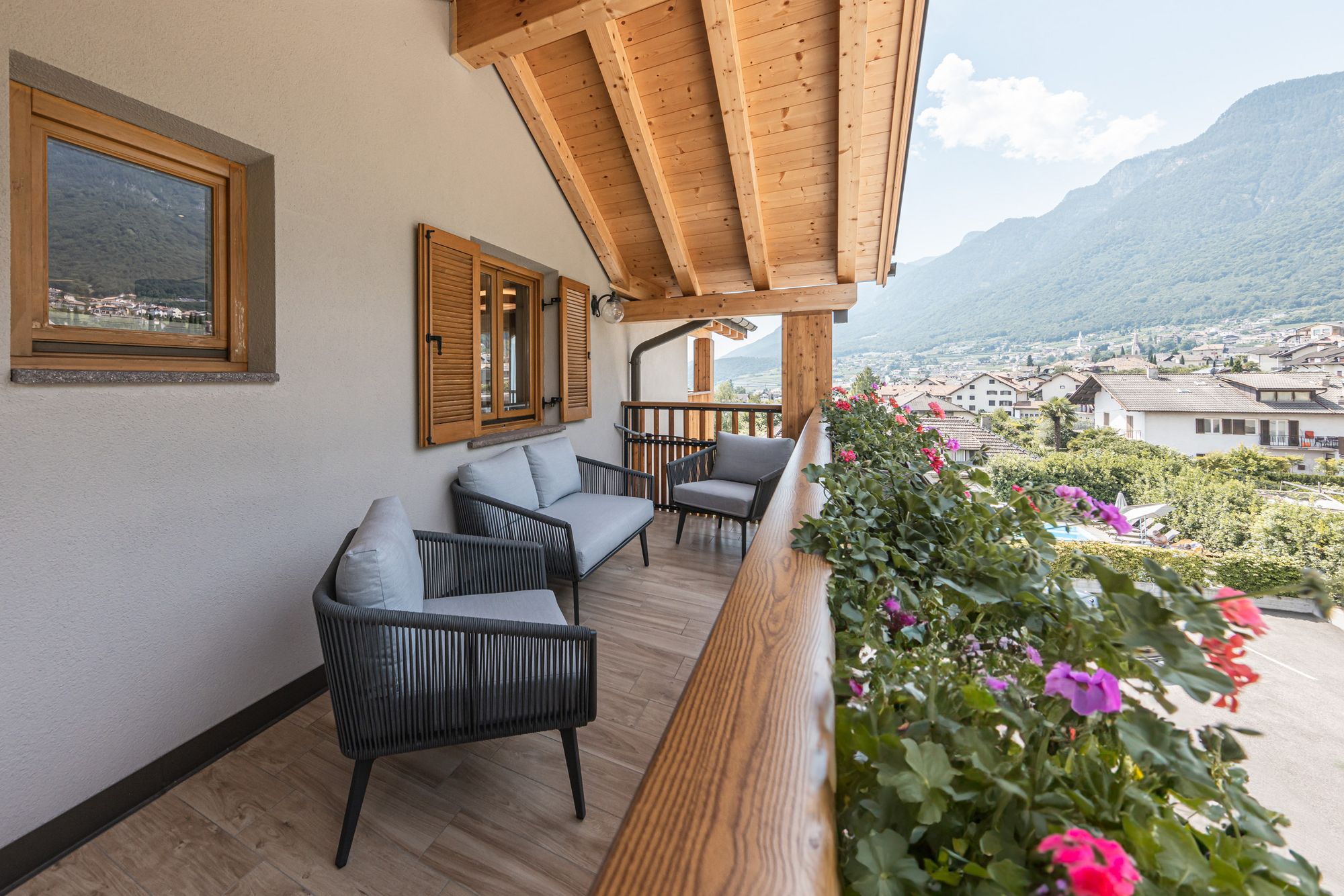 Balkon mit Sitzmöbeln, Blumen und Bergblick